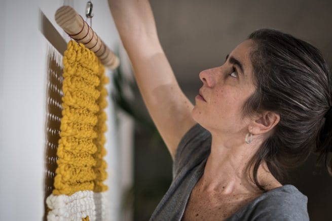 Tapiz industrial y la creadora. Vista de perfil.