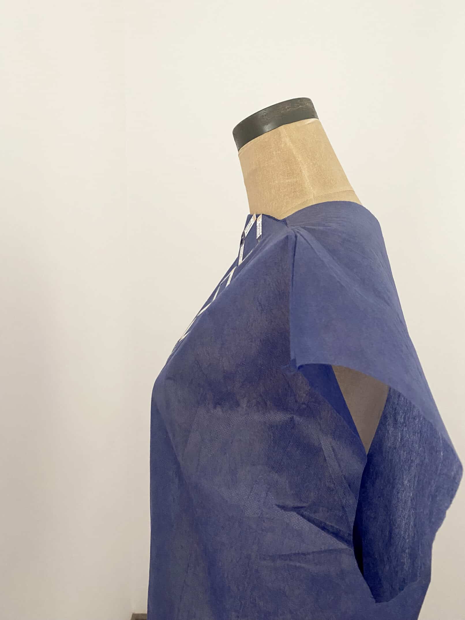 Bata desechable arte textil de la serie hospitalaria Accu Chek vista de perfil azul oscuro